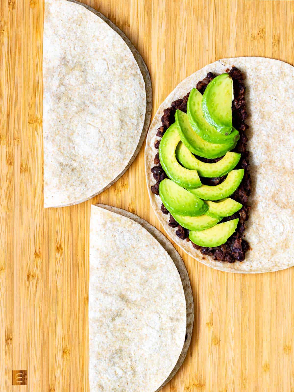 Tortillas with two vegan fillings, ready to fold in half.