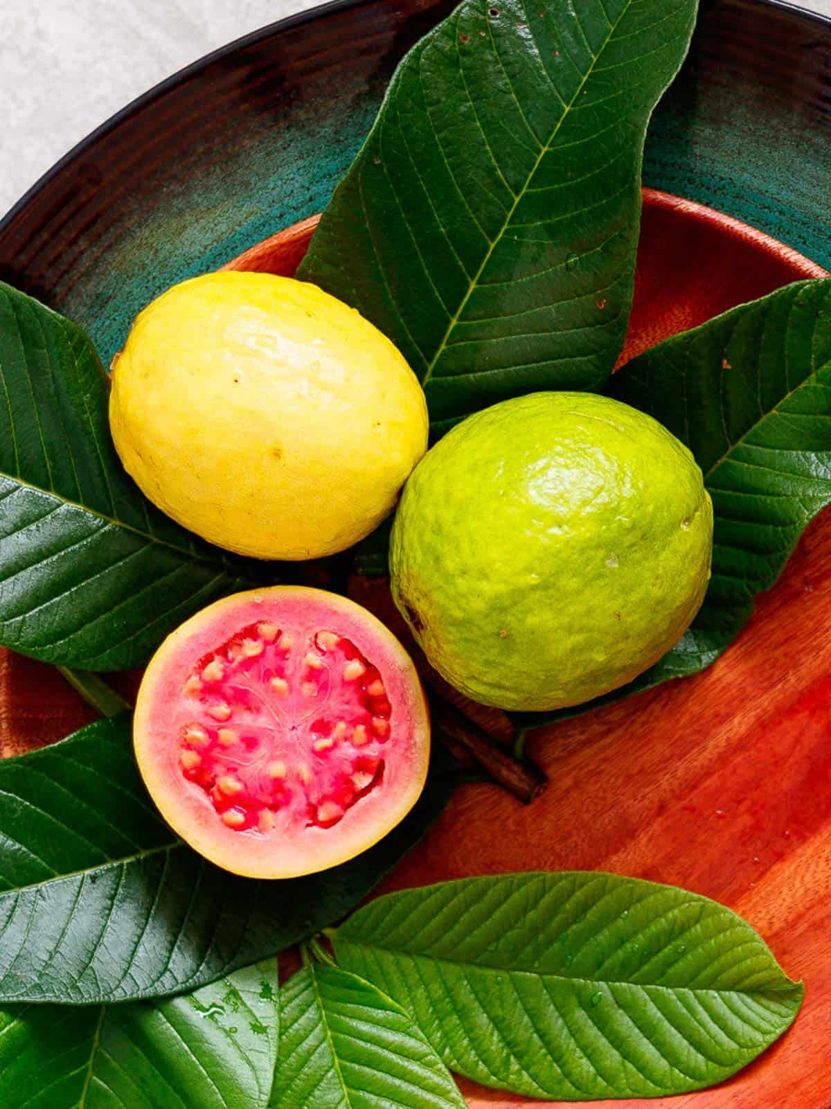 Common guava is yellow on the outside, pink inside and full of seeds.