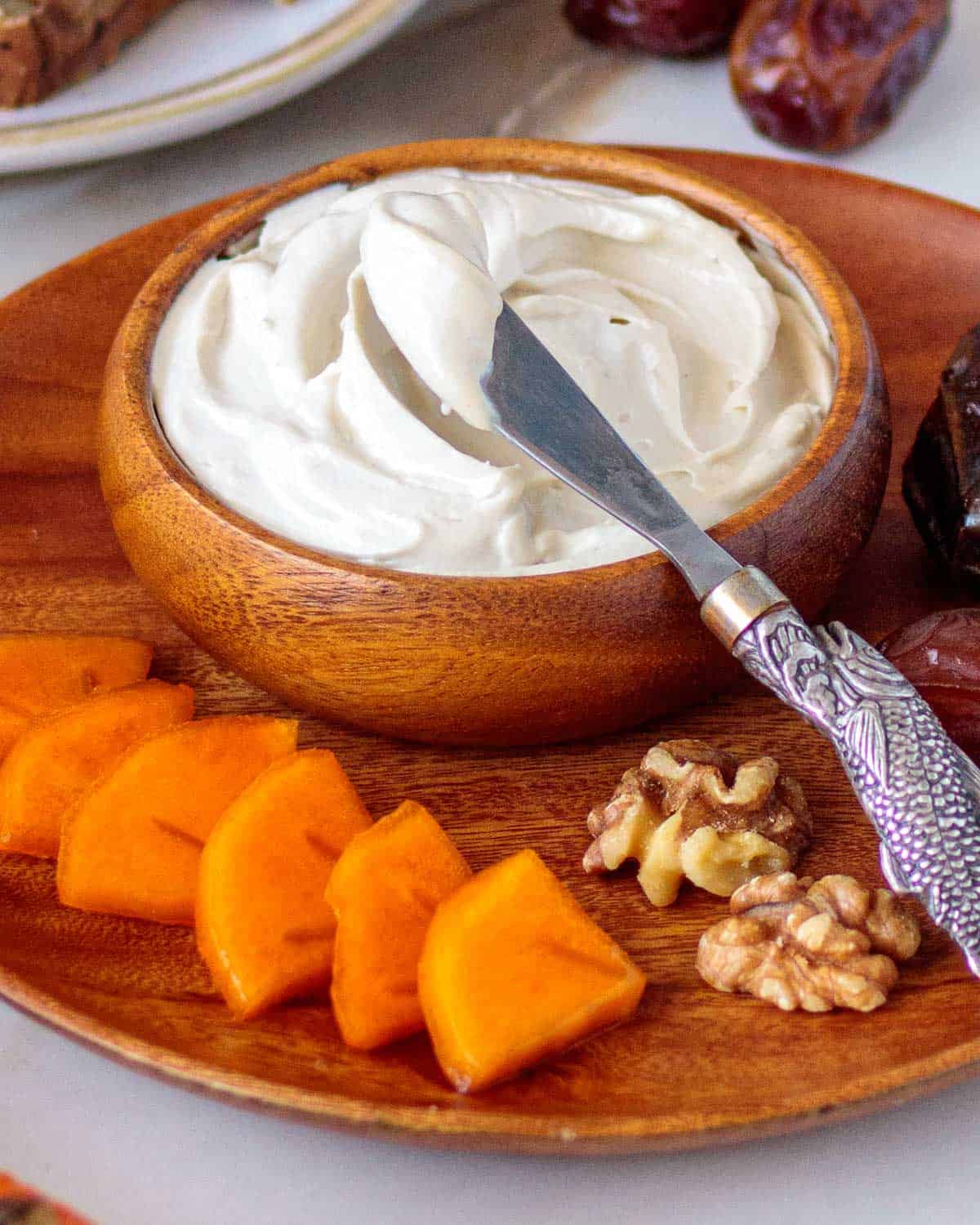 Bowl of whipped cream chees with fresh fruit and nuts.