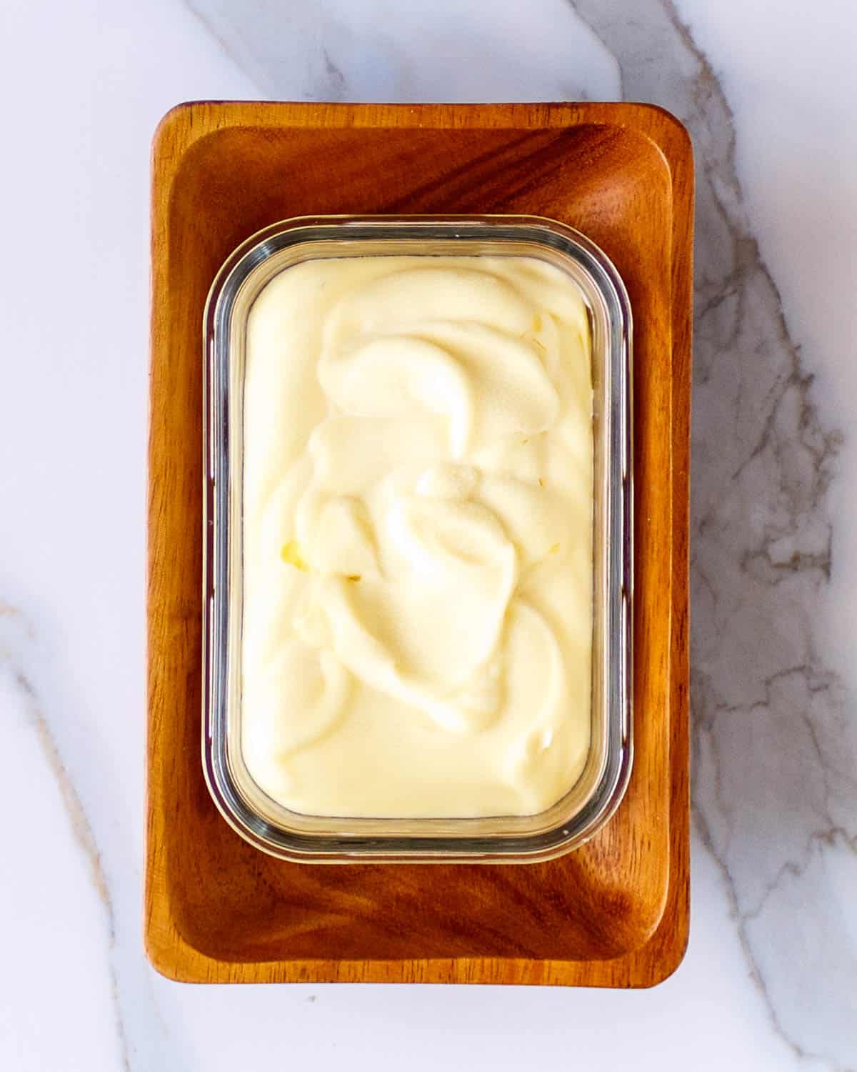 Dish of smooth homemade butter folded into a glass rectangle.