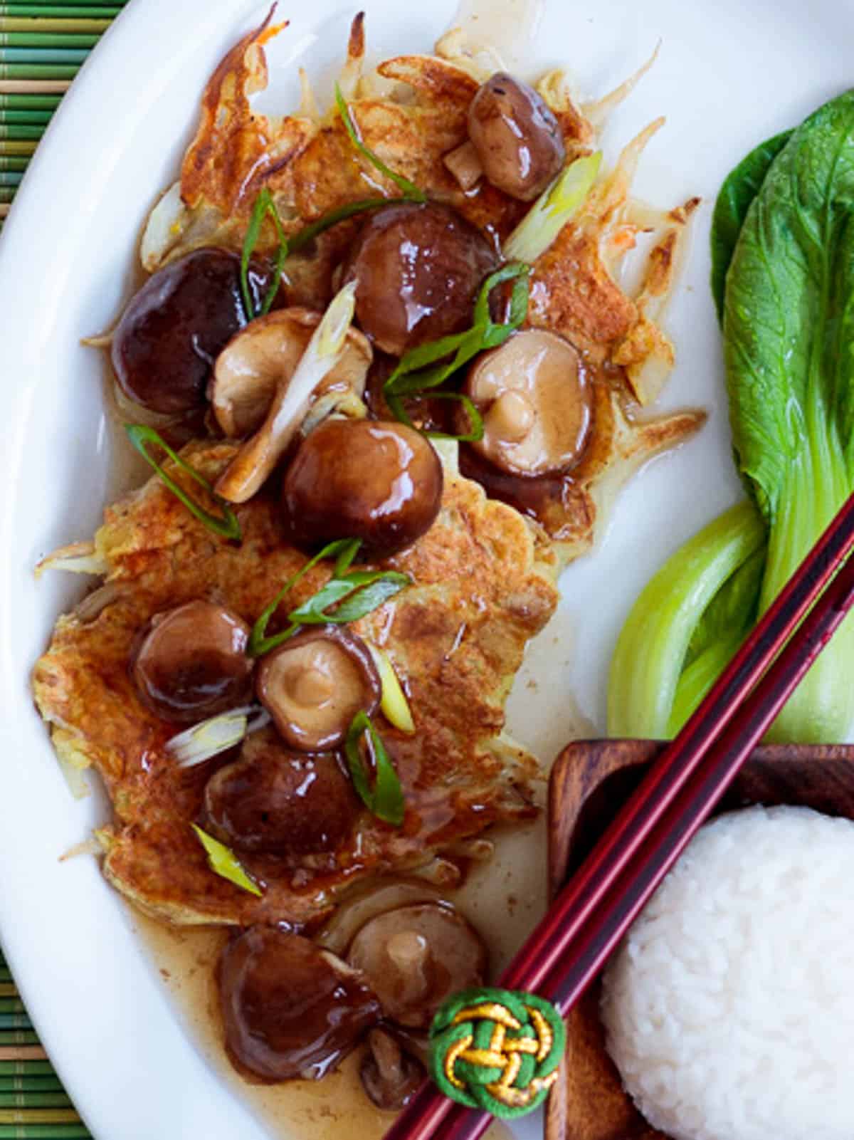 Vegan egg foo young patties topped with shiitake mushroom sauce.