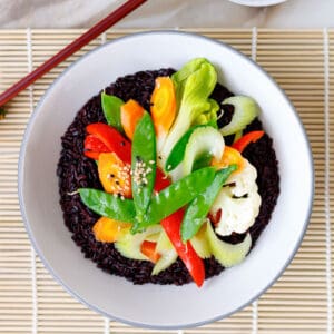 Vegan black rice with tender-crisp veggies in a bowl.