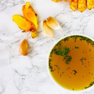 Tasty turmeric broth with parsley and rice noodles.