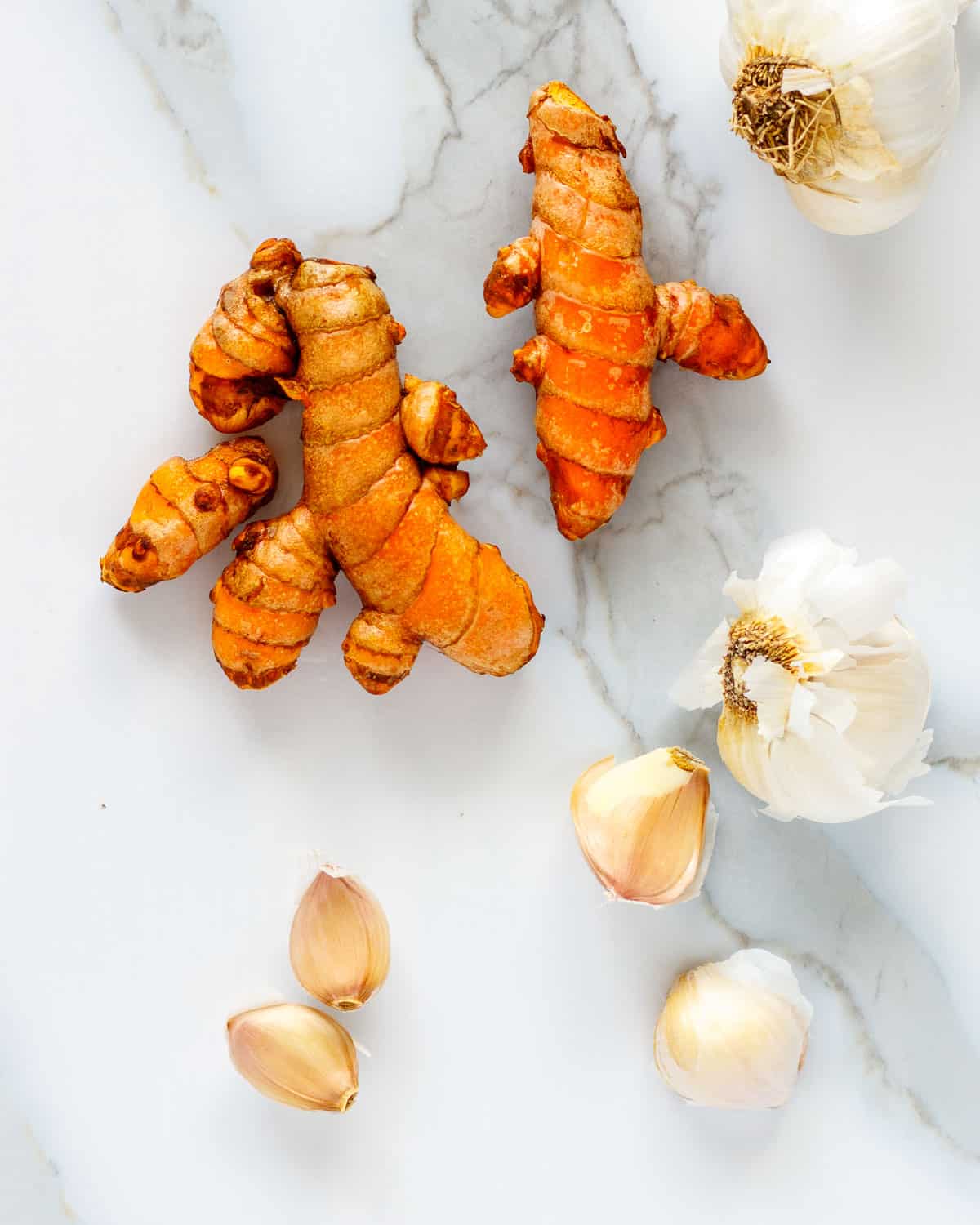 Whole turmeric root and unpeeled garlic cloves.