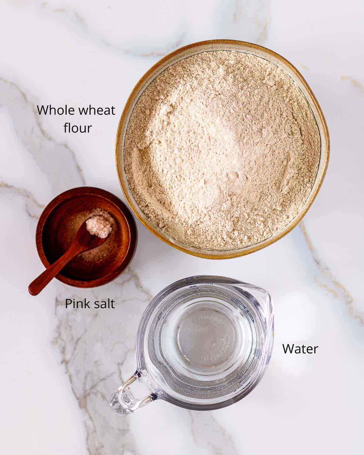 Bowl of whole whaet flour, pink salt and pitcher of water.