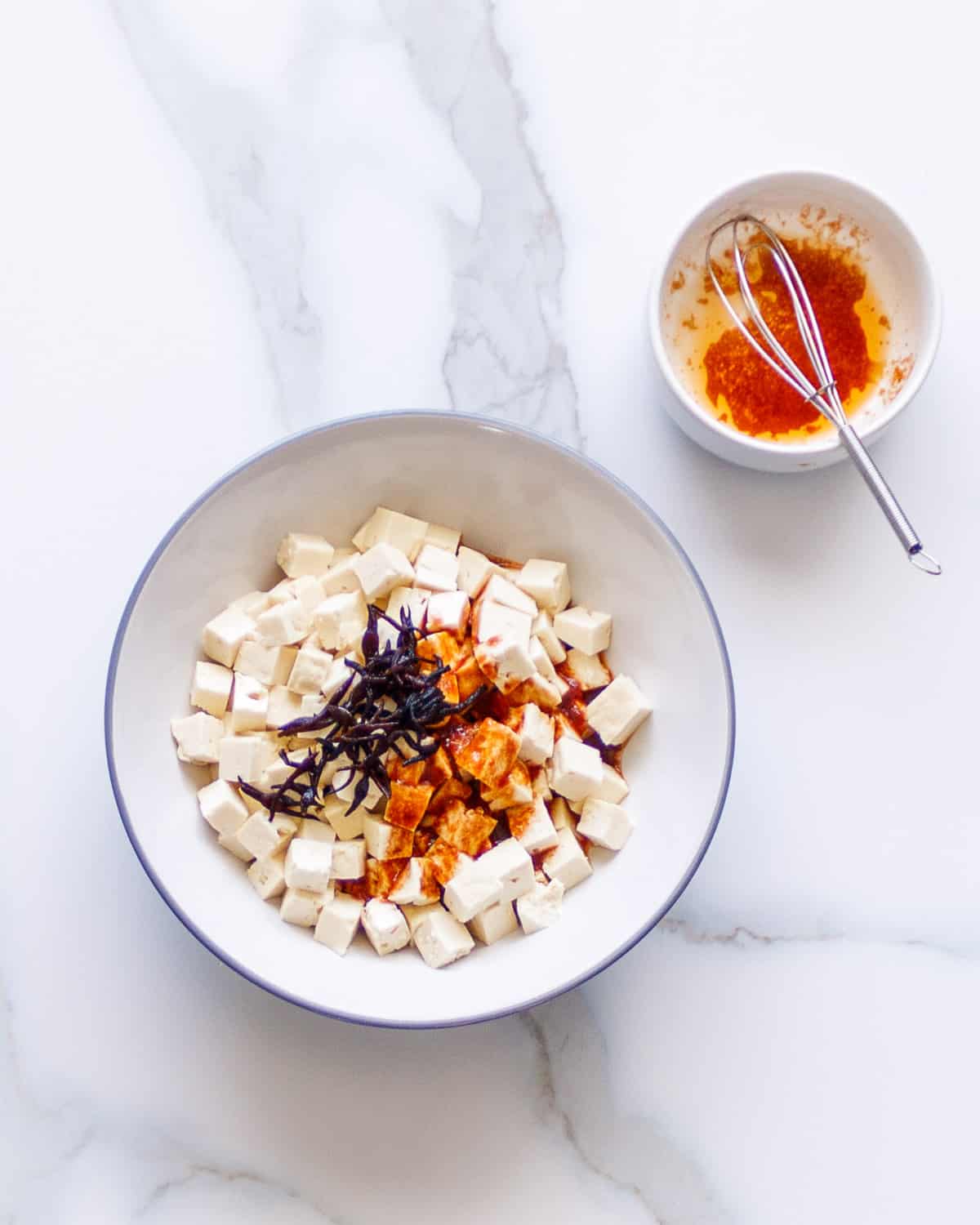 Tofu cubes with spicy sauce and seaweed.