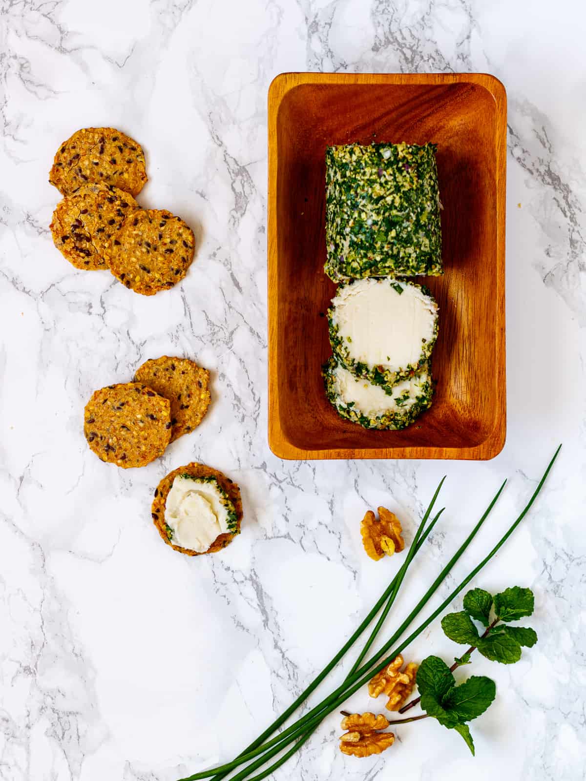 Vegan goat cheese log rolled in fresh herbs.