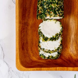 Vegan goat cheese log rolled in fresh herbs.