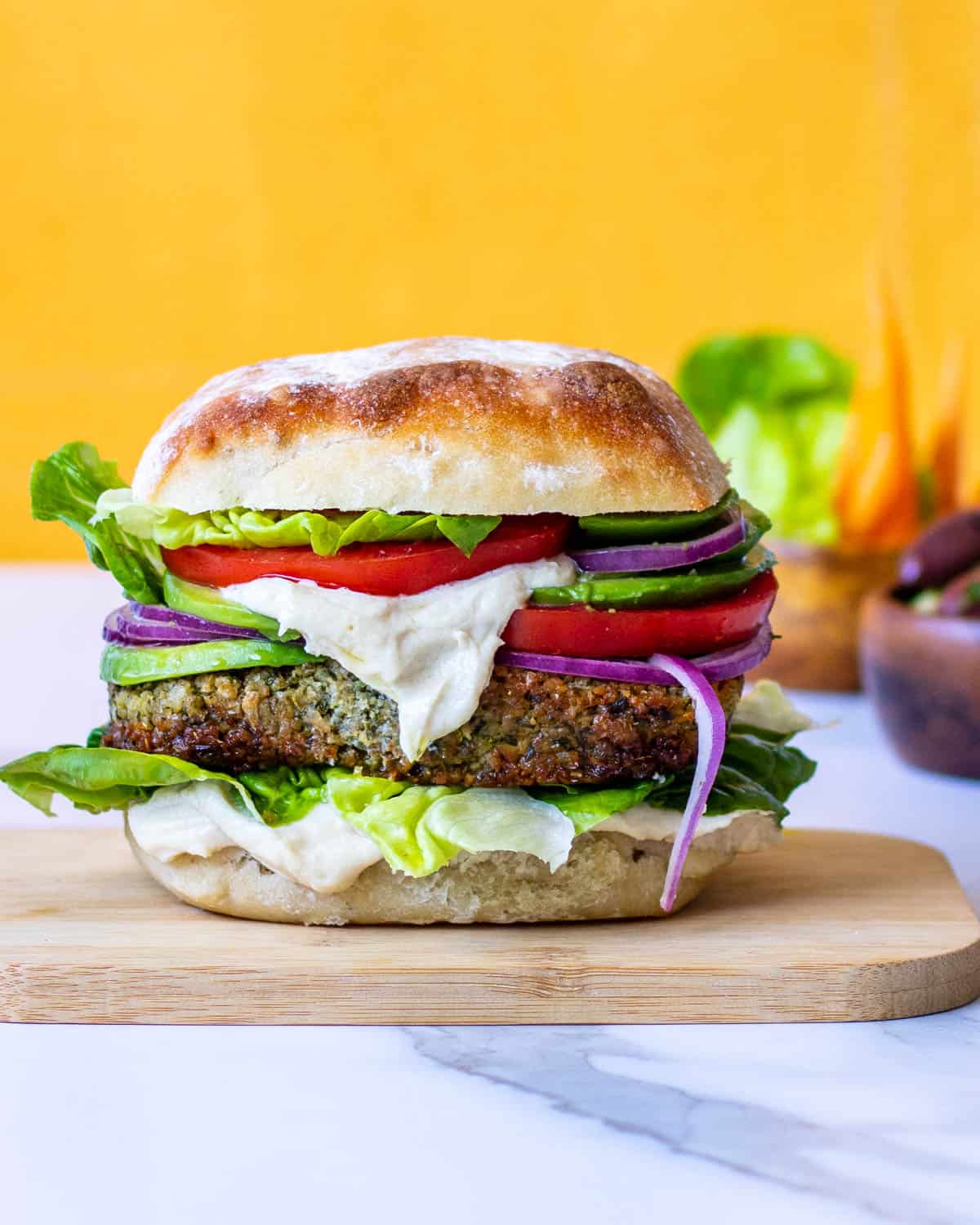 Fat felafel sandwich with fixings and tahini sauce.
