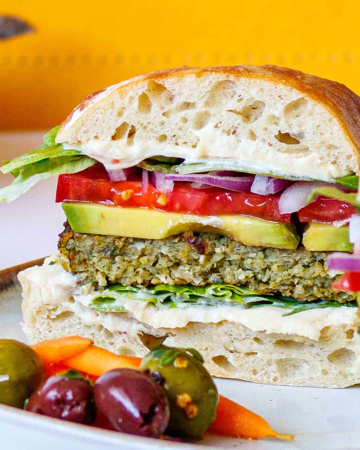 Cross section of a layered falafel sandwich with thick tahini.