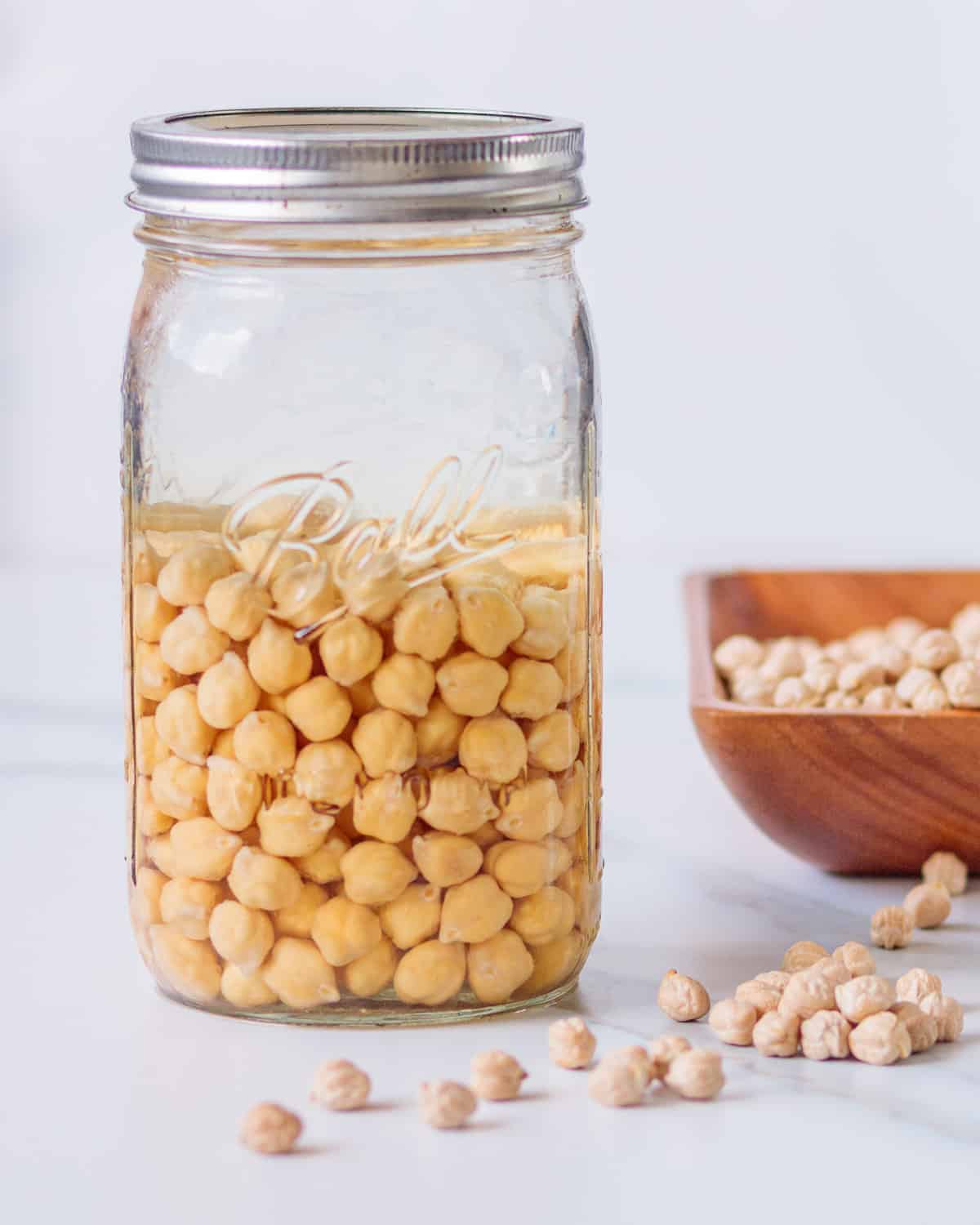 Chickpeas soaking in a jar of water.