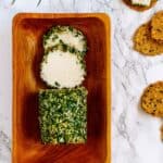 Dairy-free goat cheese log rolled in herbs with crackers.