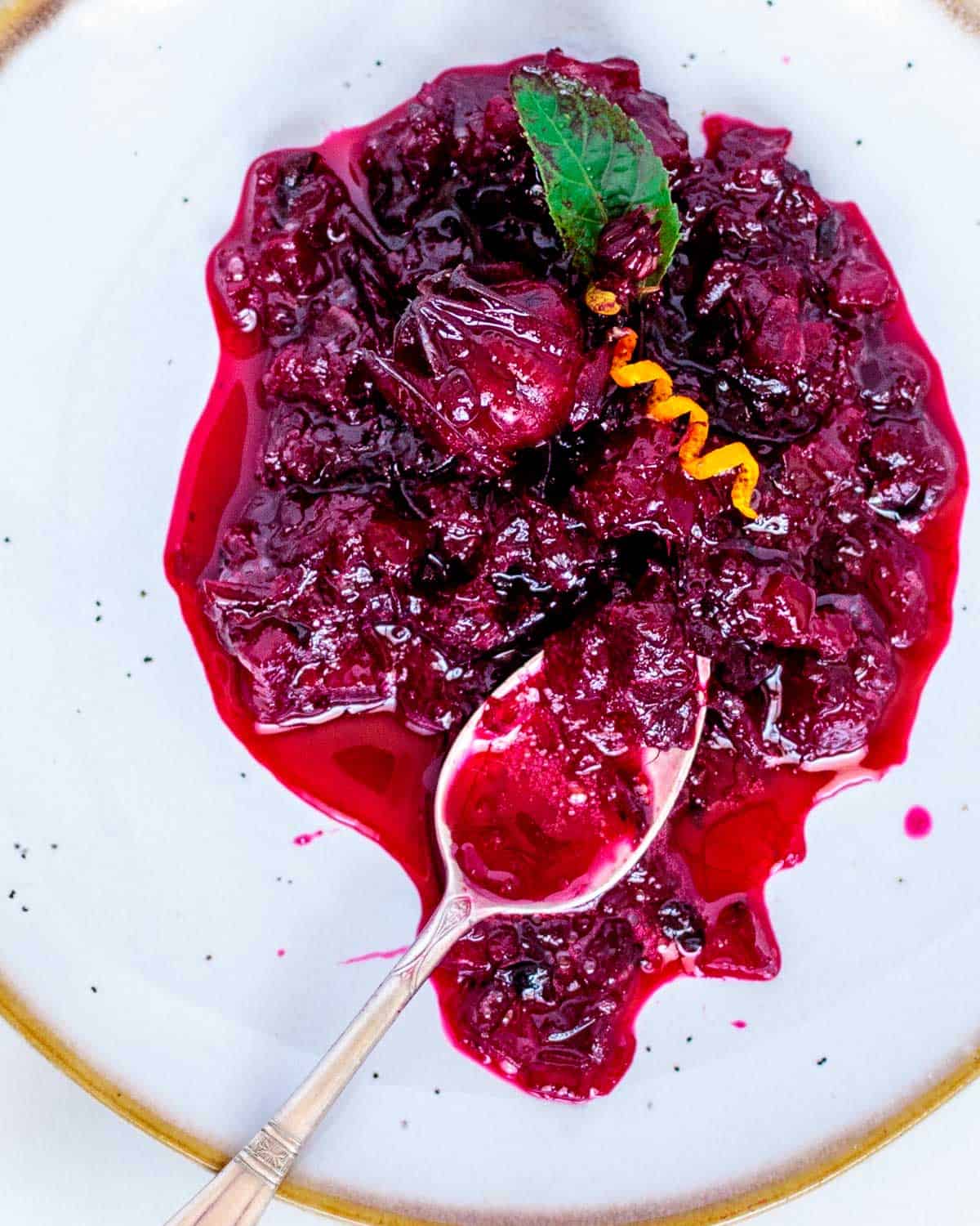 Juicy thick cranberry sauce on a spoon.