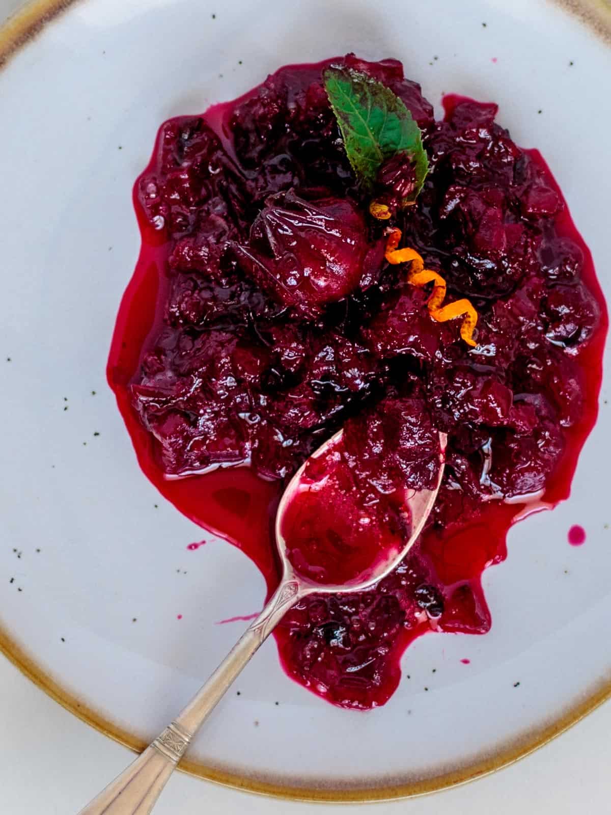 Juicy thick cranberry sauce made from the Jamaican sorrel plant on a spoon.