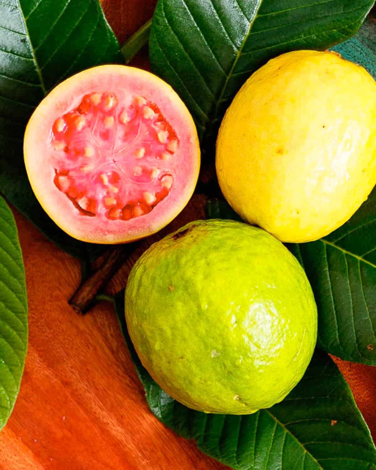 Ripe and unripe guava shown with cross section of pink fruit.