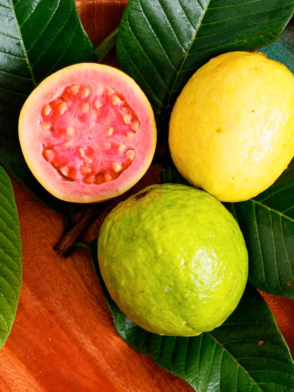 Ripe and unripe guava shown with cross section of pink fruit.