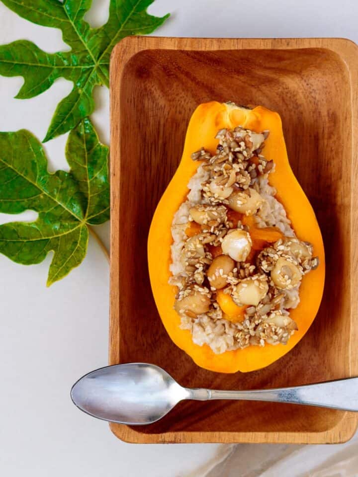 Half a papaya filled with cooked oats and topped with sweet granola.