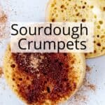 Two buttered vegan crumpets topped with butter and cinnamon sugar.