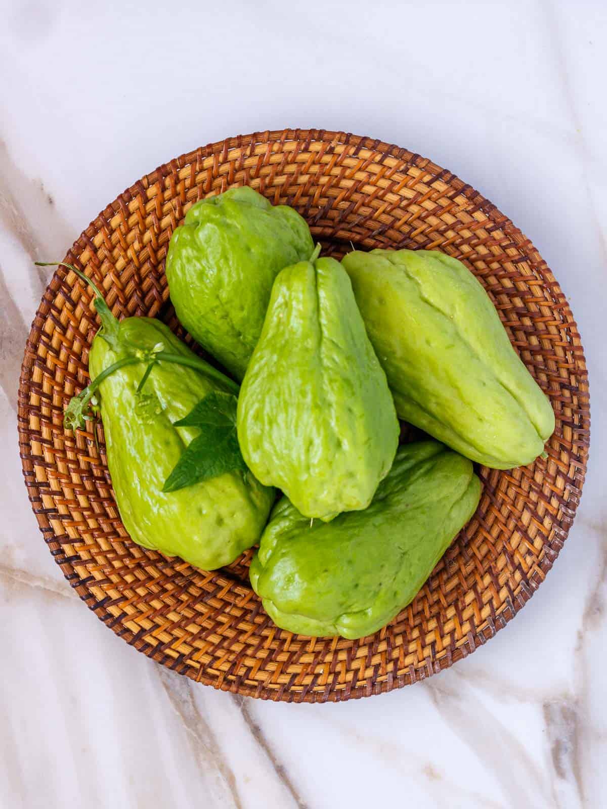 Basket with five whole chayote squash.