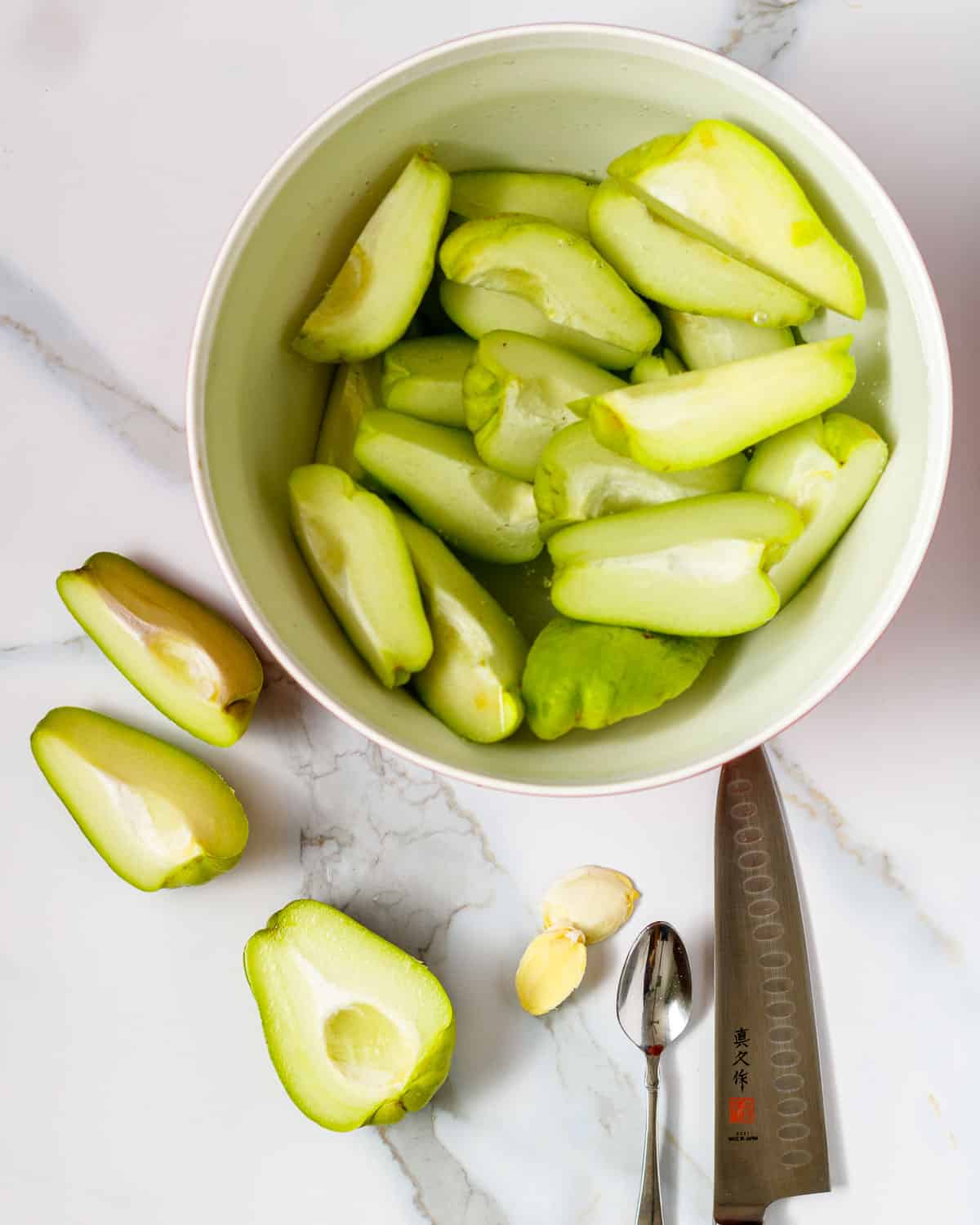 Cut chayote in a bowl of water.