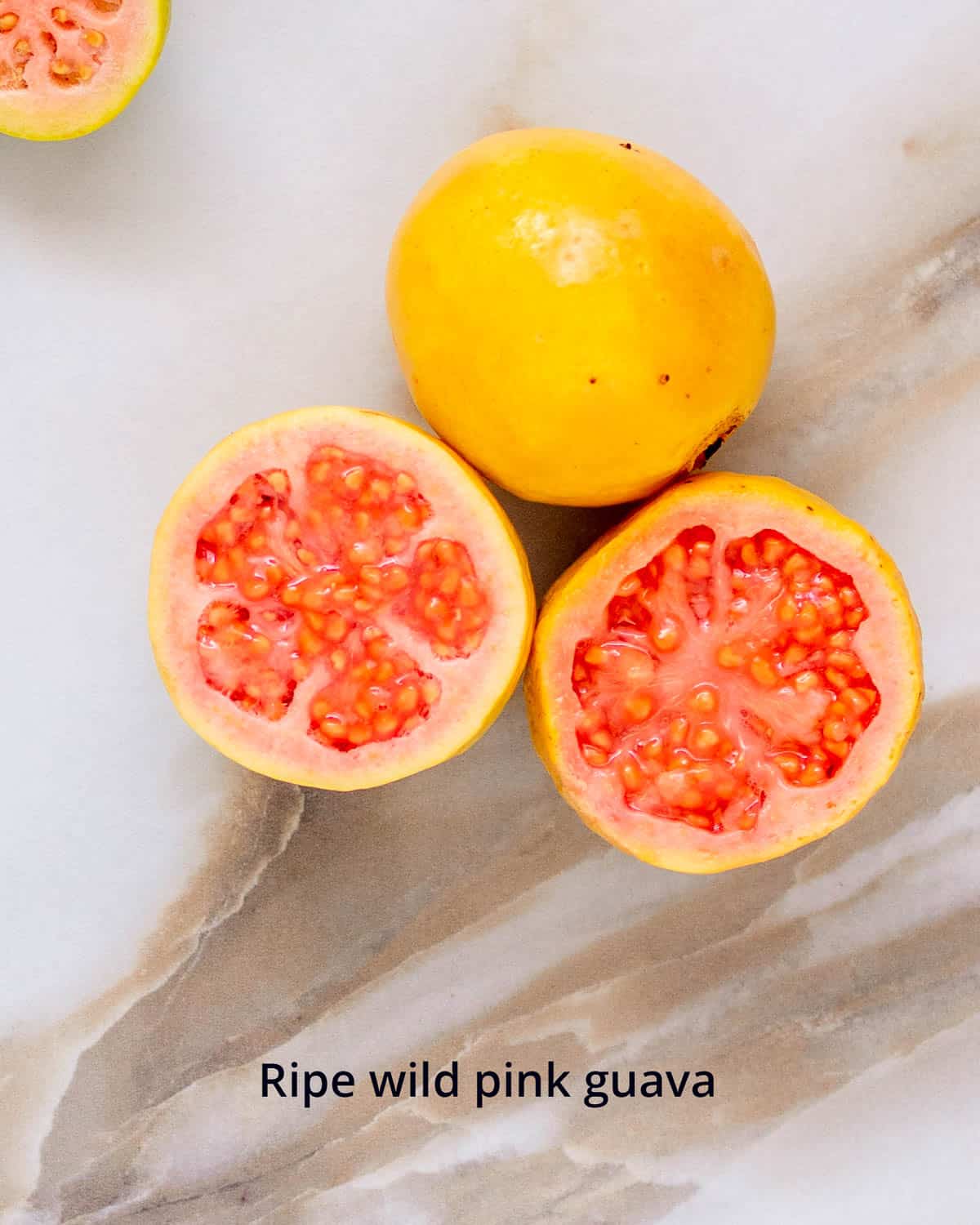 Fully ripe guava with yellow skin and soft pink interior.