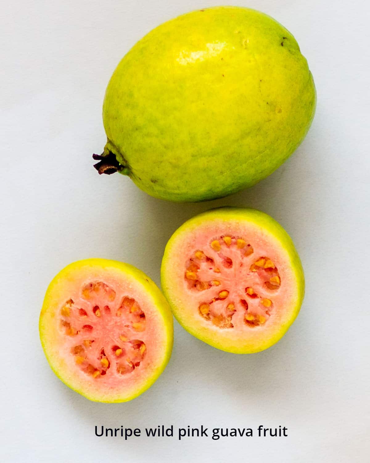 Unripe pink guava cut in half.