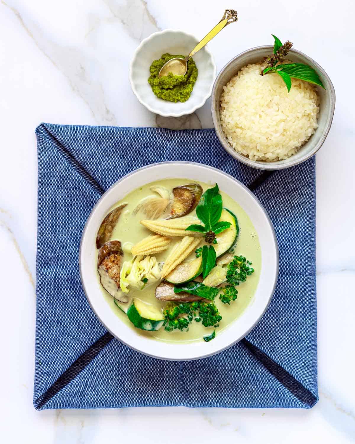 Bowl of green vegetable curry with rice.