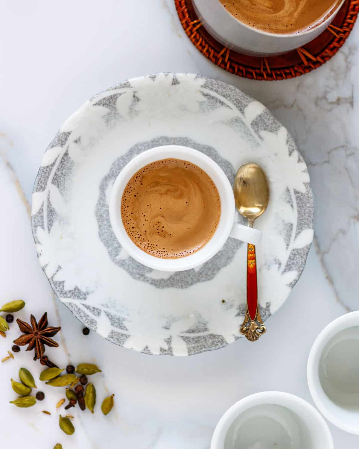 Small cup of Indian spiced tea on a saucer.
